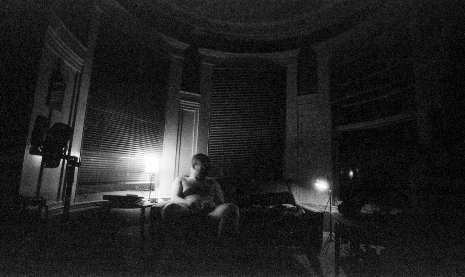 Zach sitting on a couch naked in the dark.