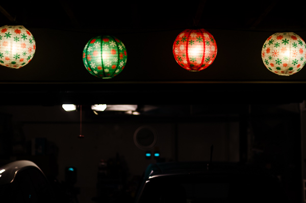 Holiday landers hanging outside a garage at night